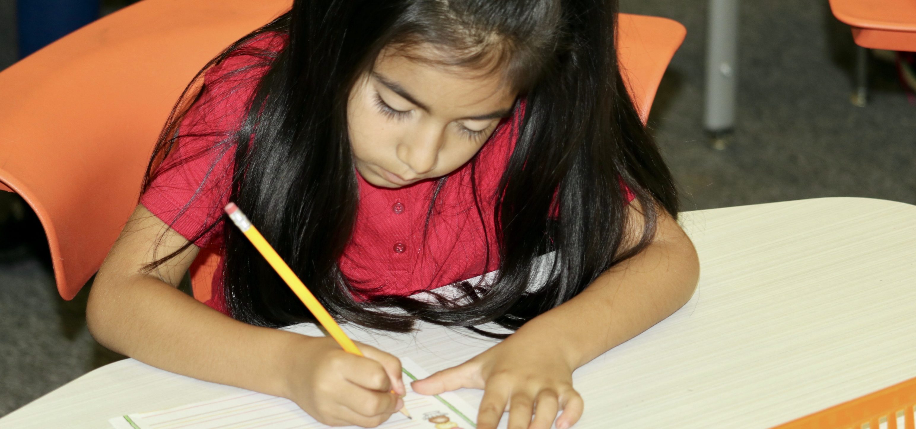 Girl in first grade concentrates on her schoolwork.